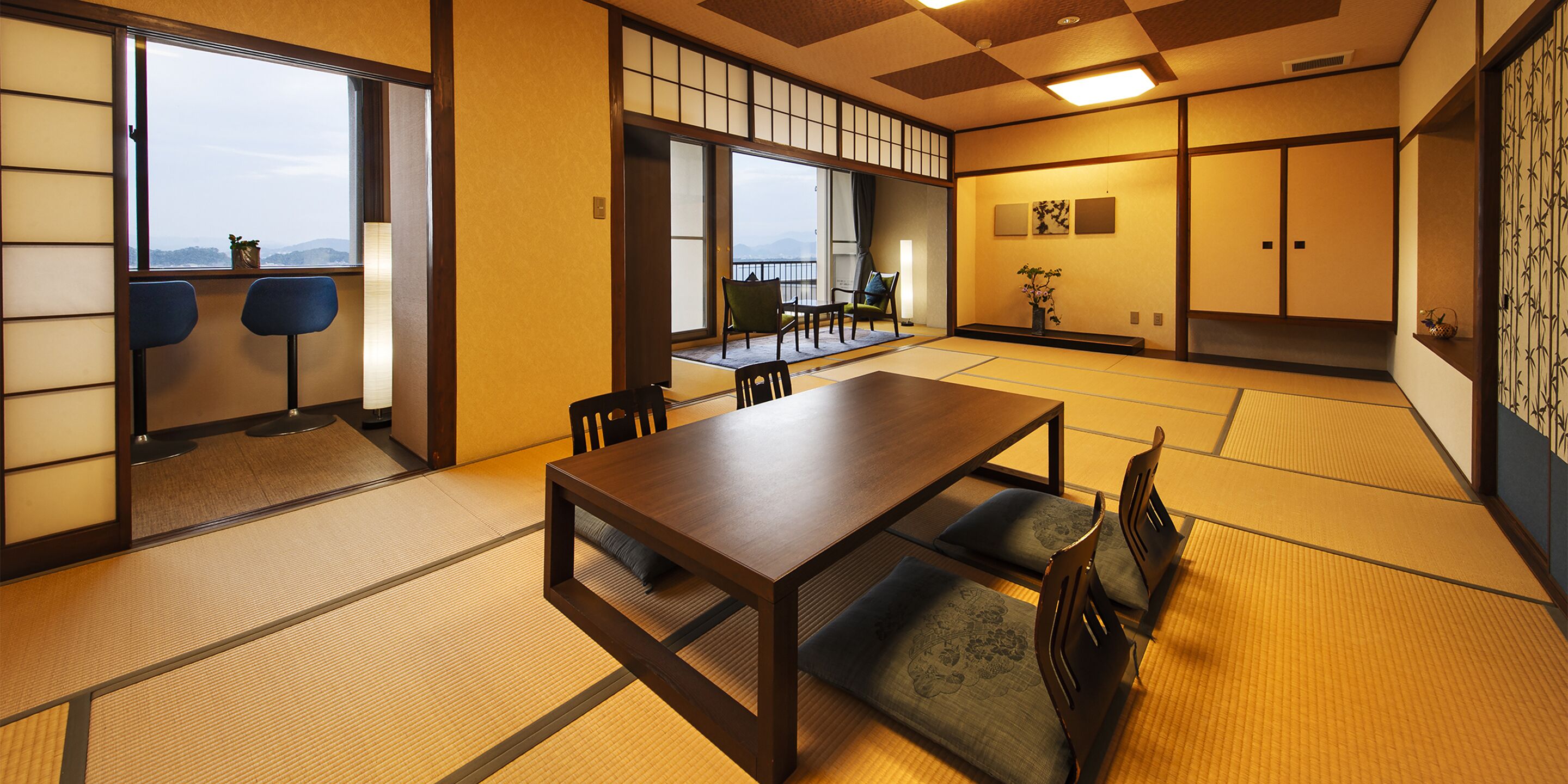 A traditional Japanese room with tatami flooring, a low wooden table, and a view of the outdoors.