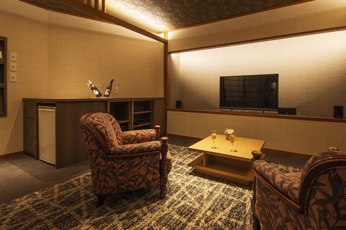 Una sala acogedora con muebles estampados, un televisor de pantalla plana y una pequeña mesa de centro.