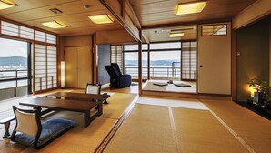 A traditional Japanese room with tatami flooring, a low table, and a seating area with cushions. - Manpa Resort (Wakayama)