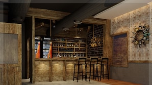 Zona de bar con taburetes de madera, estantes llenos de botellas y pared de ladrillo.