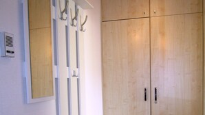 A room with a wooden wardrobe, a white console table, and a mirror with decorative hooks. - Modern and quiet apartment right in the city center of Berlin (Berlin)
