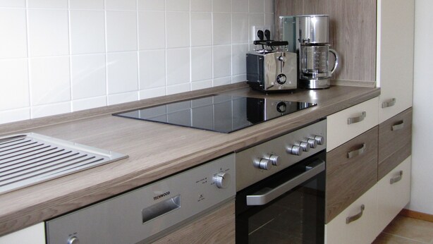 A modern kitchen with a stainless steel range, a built-in oven, and a coffee maker. - Modern and quiet apartment right in the city center of Berlin (Berlin)