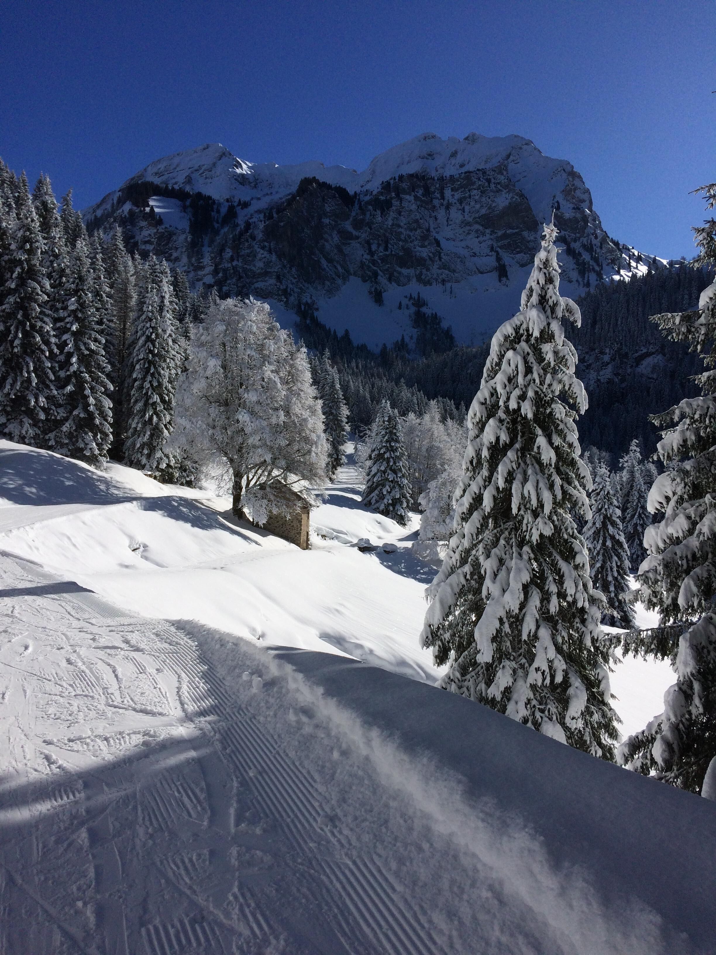 Eine verschneite Berglandschaft mit blauem Himmel.