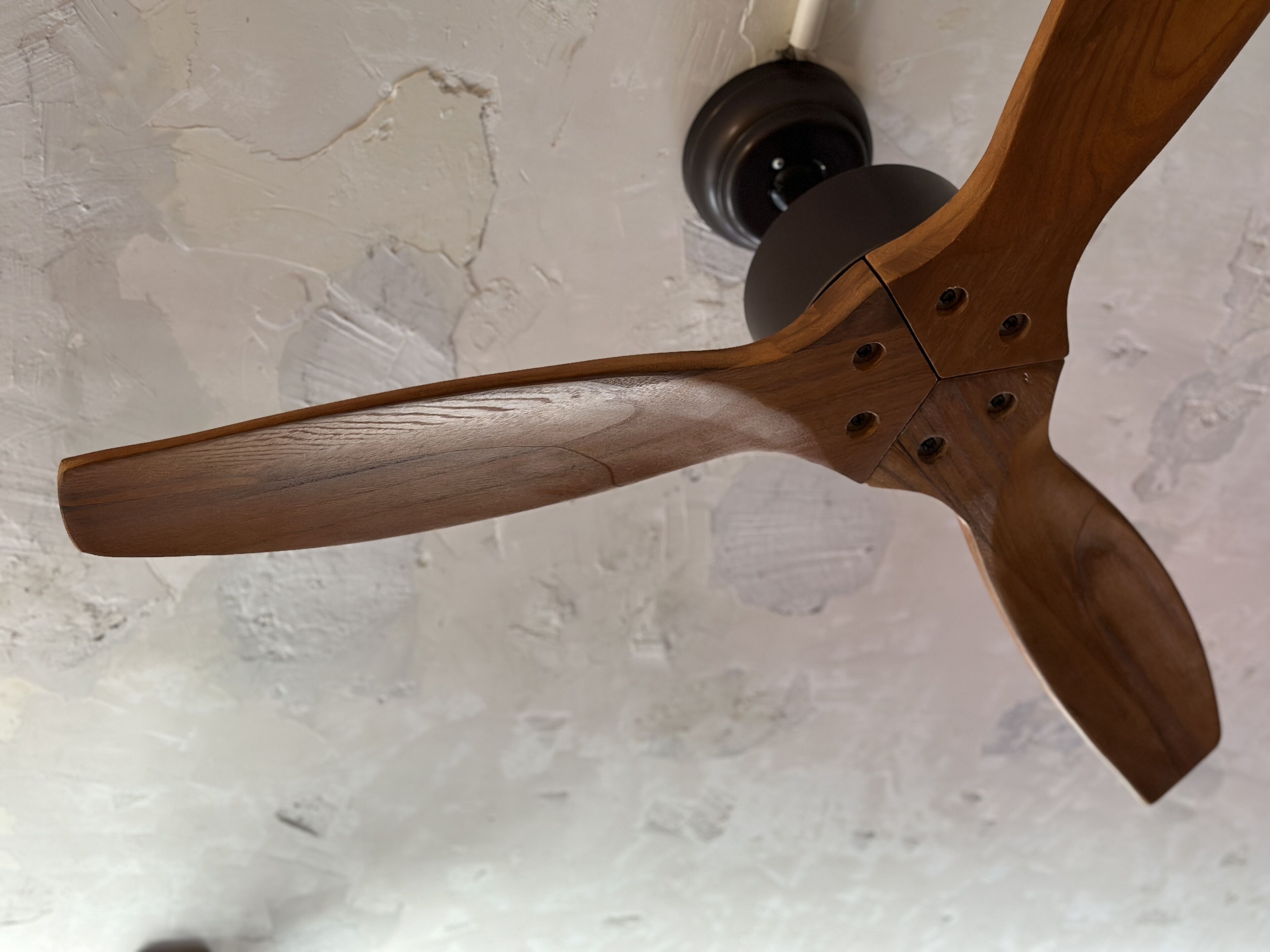 A ceiling fan with a wooden blade design.