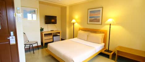 Minibar, escritorio, tabla de planchar con plancha y ropa de cama