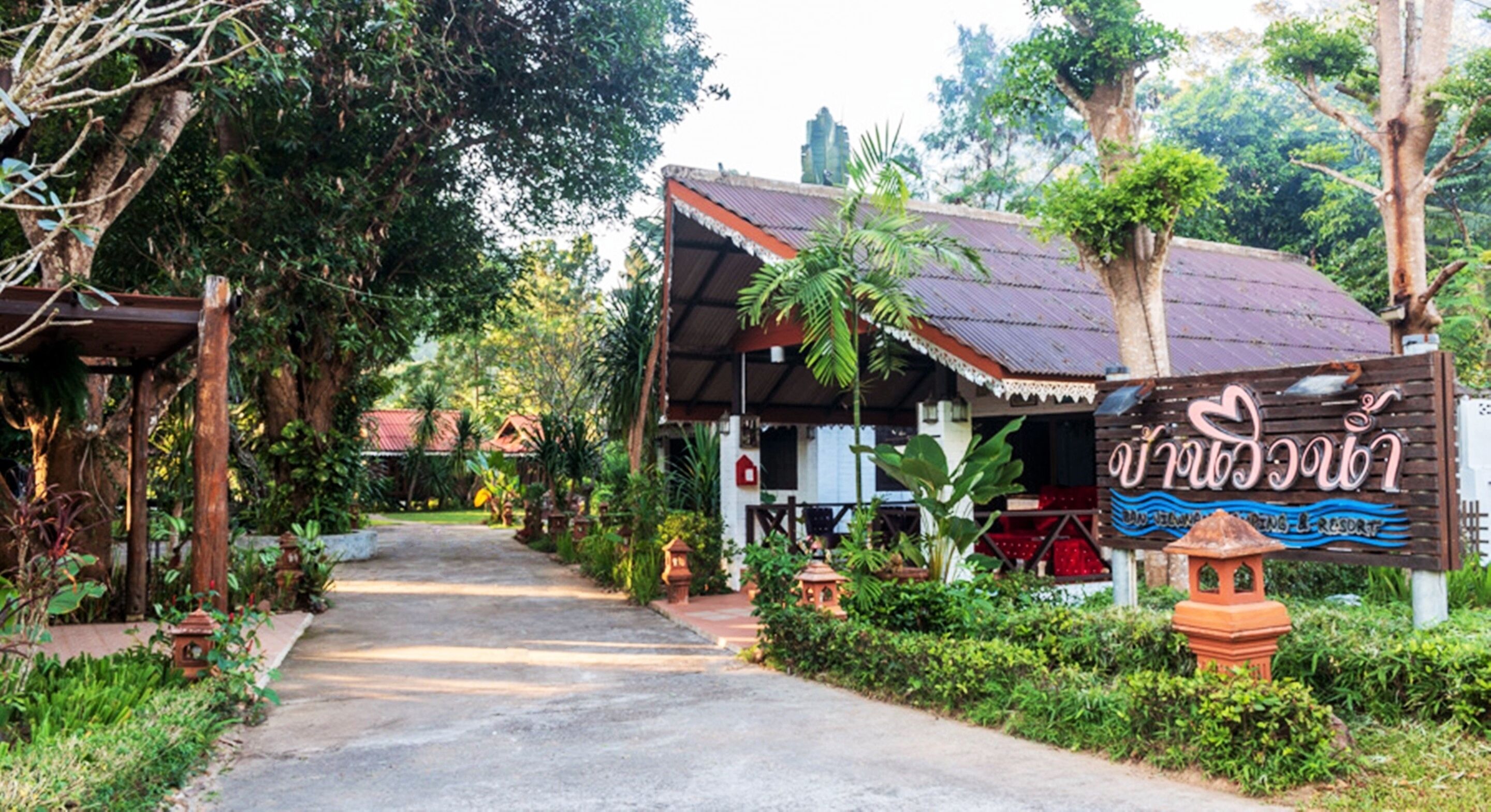 A pathway leading to a building with a sign indicating a restaurant.