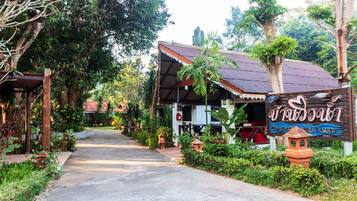 A pathway leading to a building with a sign indicating a restaurant.