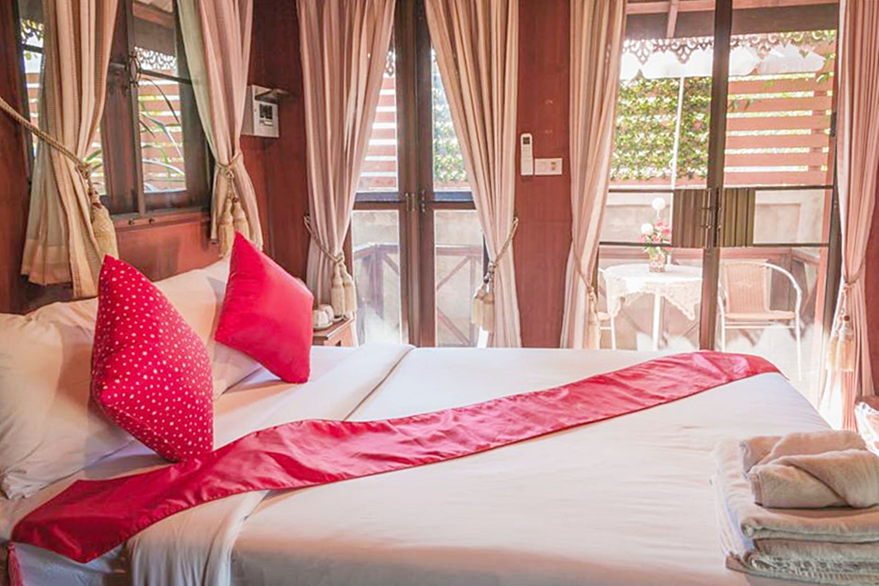 Une chambre à coucher avec un lit, des rideaux, une fenêtre et une vue sur l’extérieur.
