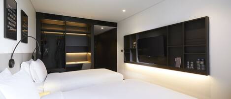 Habitación de hotel moderna con una cama grande, televisión integrada y un vestidor con iluminación.