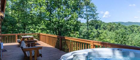 A wooden deck with outdoor seating and a hot tub.