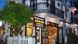 A two-story building with a balcony and a signboard advertising a homestay. - Quynh Chau Homestay (Da Nang)