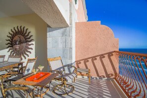 A sun-shaped wall decoration, a table with chairs, and a railing overlooking the sea. - Sonoran Sun E-1005 Sunrise Perch Penthouse Nice Decor Large Patio Ocean Front Condo (Puerto Penasco)