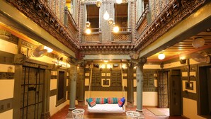Une pièce somptueuse avec un lit suspendu, un sol à motifs et des colonnes décoratives.