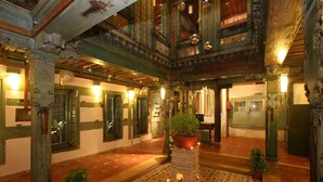 Un intérieur richement décoré, avec une colonne centrale, un sol à motifs et un décor traditionnel.