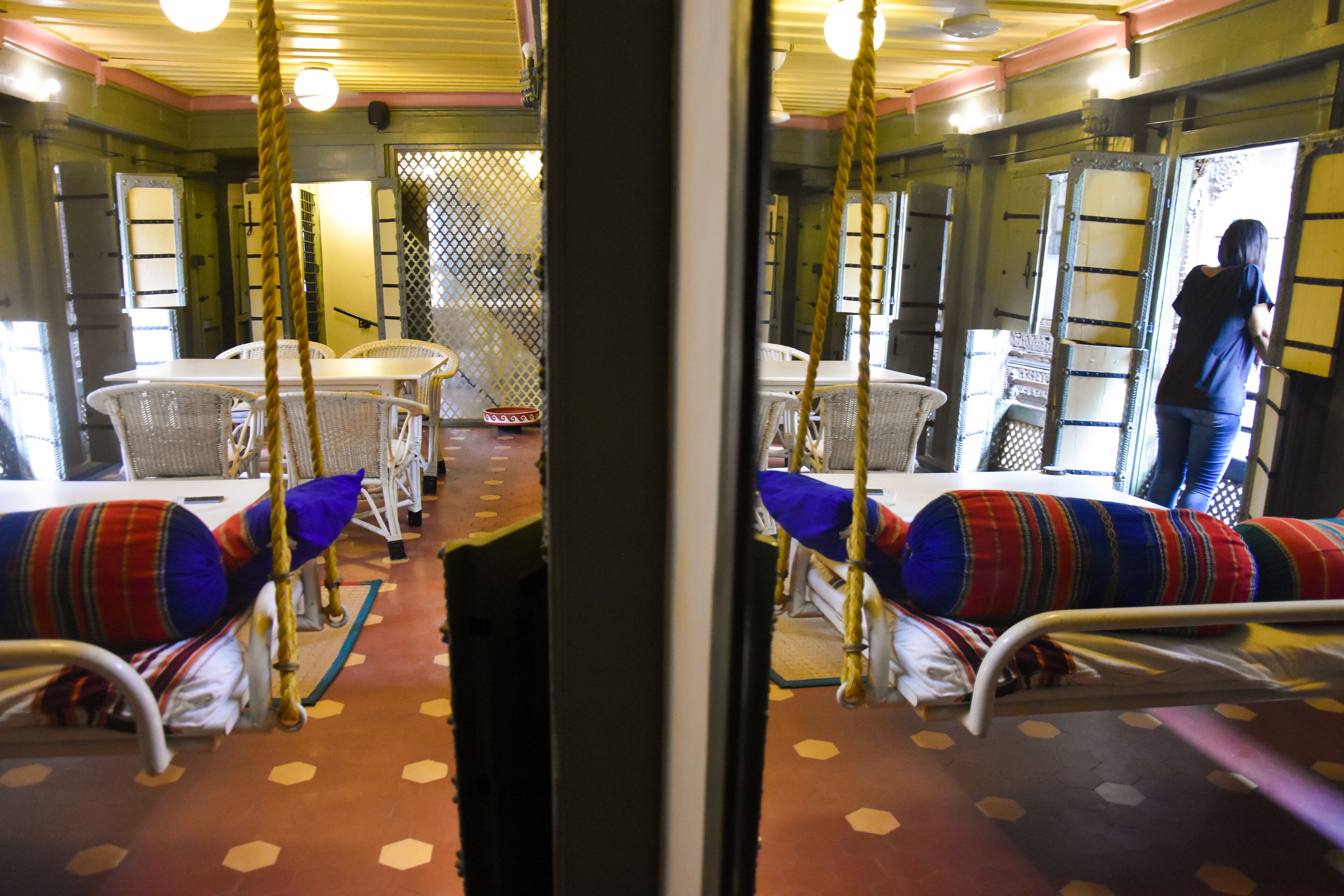 A train car with bunk beds, a dining area, and a window with a view.