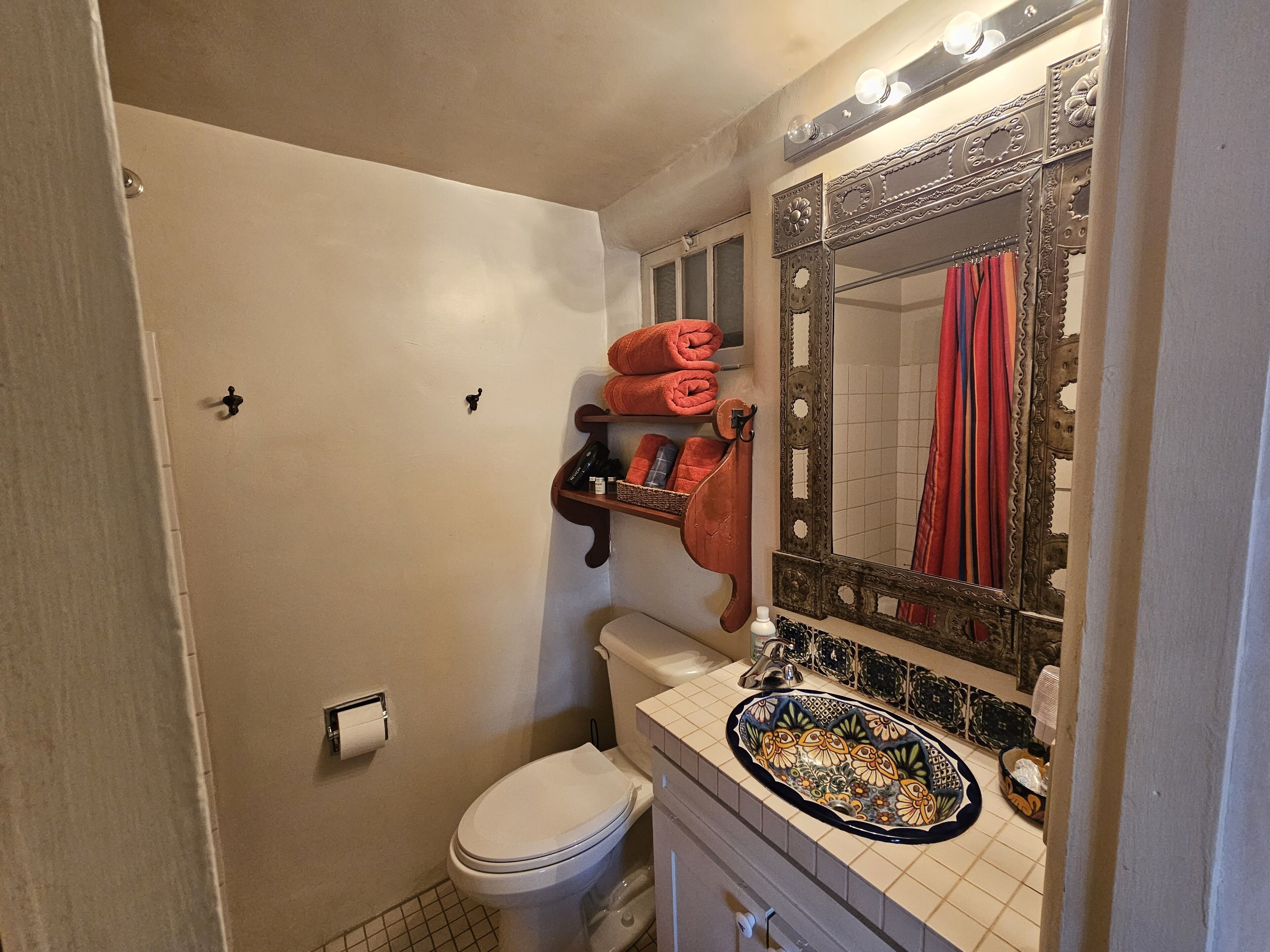 Ein Badezimmer mit Toilette, Waschbecken und einem Spiegel mit Zierrahmen.