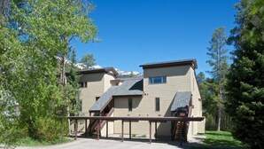 A two-story building with a sloped roof, a staircase leading to the upper level, and a covered outdoor area.