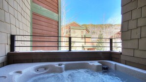 Un jacuzzi con vista a un edificio y árboles.