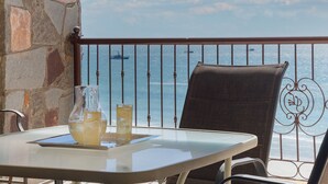 A balcony with a table, two glasses of lemonade, and a chair.