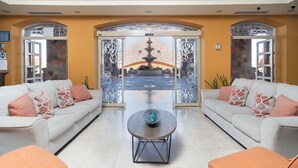 A spacious lobby with two sofas facing a decorative glass door leading to an outdoor area with a fountain.