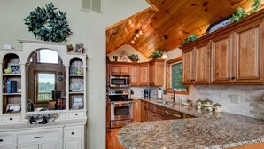 Eine Küche mit Holzschränken, Granit Arbeitsplatten und Edelstahlgeräten.