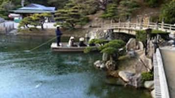 A traditional Japanese garden with a stone bridge, koi pond, and a small pavilion.