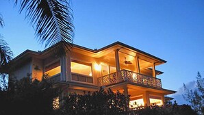 Une maison à deux étages avec un balcon et une piscine.