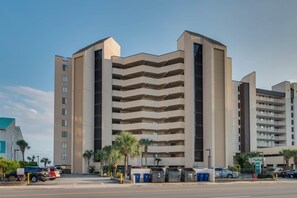 A multi-story hotel with a modern architectural design, featuring a series of balconies on each floor.