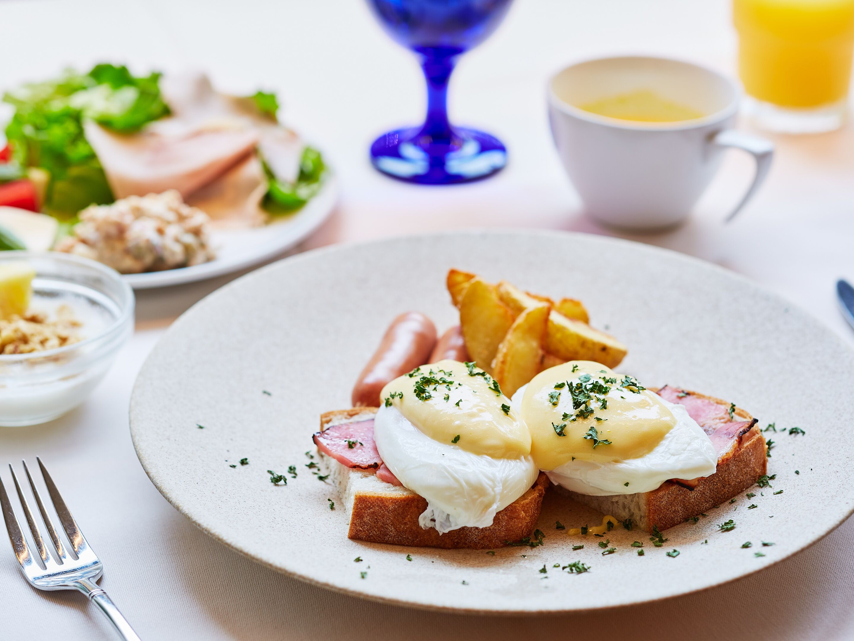 A breakfast plate with eggs, ham, and potatoes.
