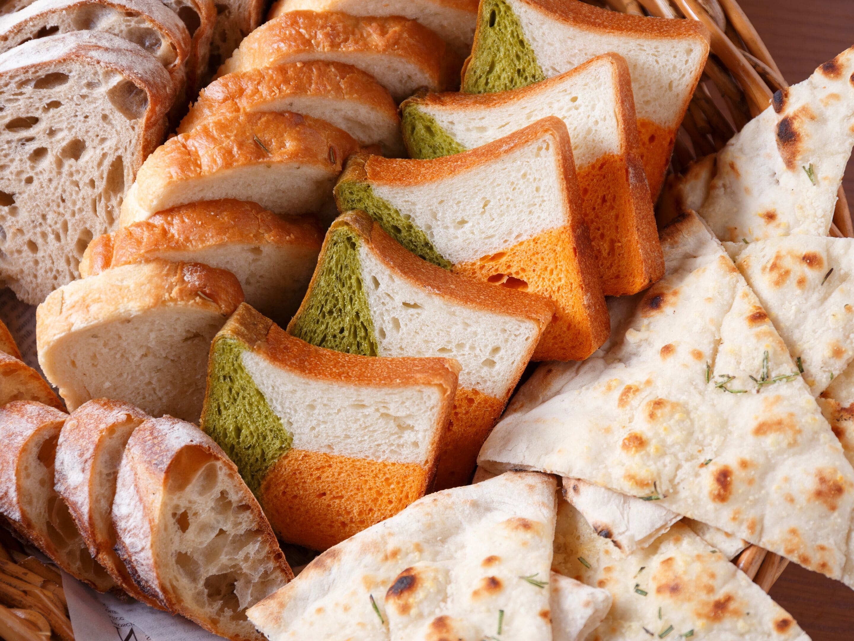 A basket of sliced bread and flatbreads.