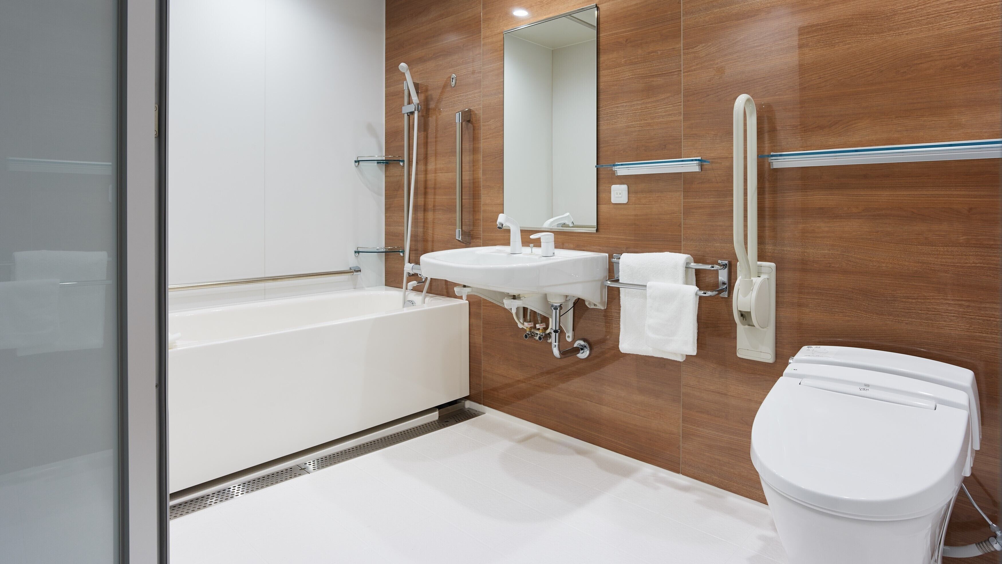 A modern bathroom with a bathtub, sink, and toilet.