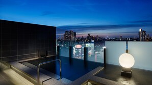 A rooftop pool with a cityscape view, a glass barrier, and a modern light fixture. - Mitsui Garden Hotel Gotanda Tokyo (Tokyo)