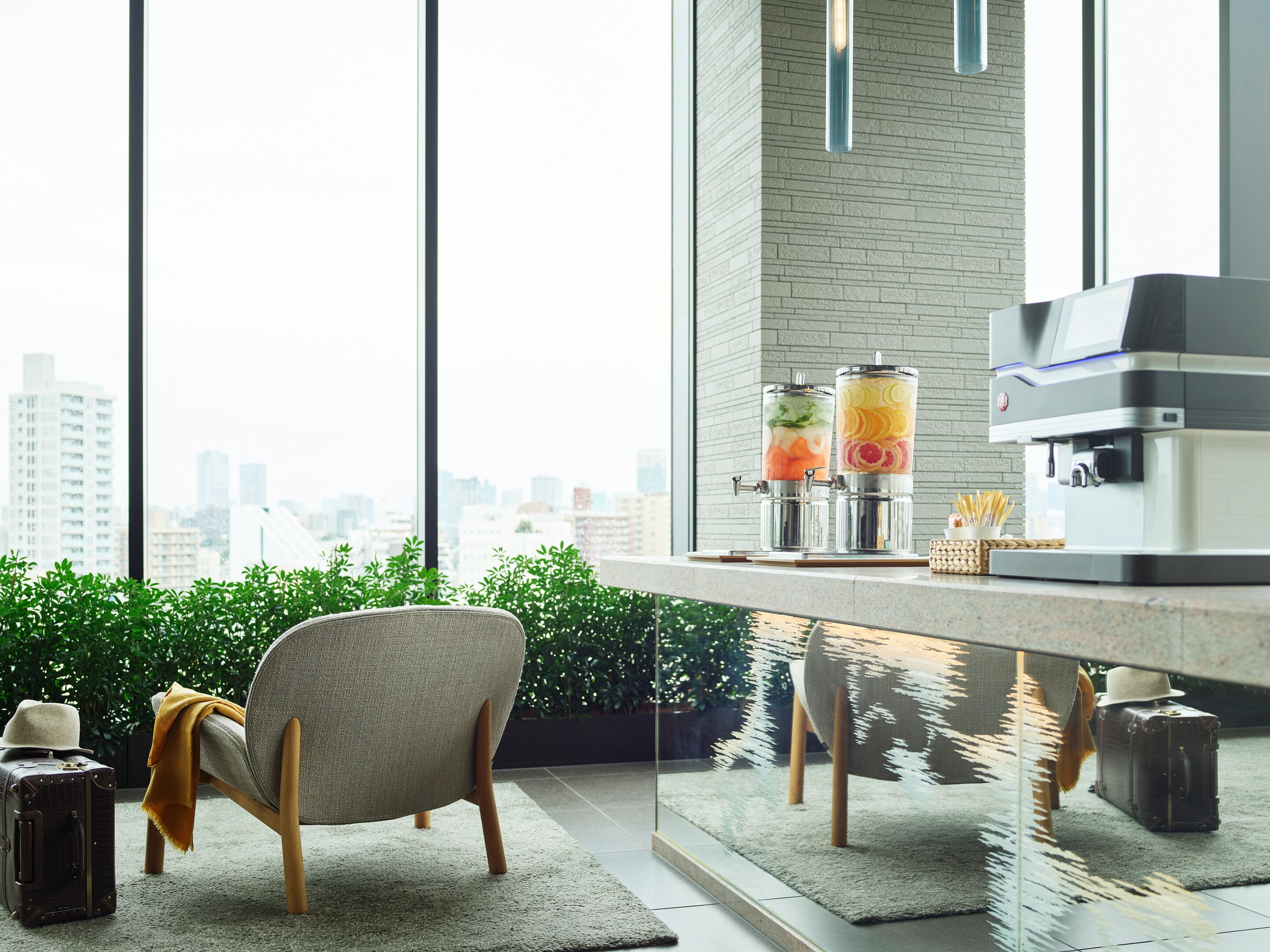 A modern interior with a large window, a seating area, a beverage station, and a coffee machine.