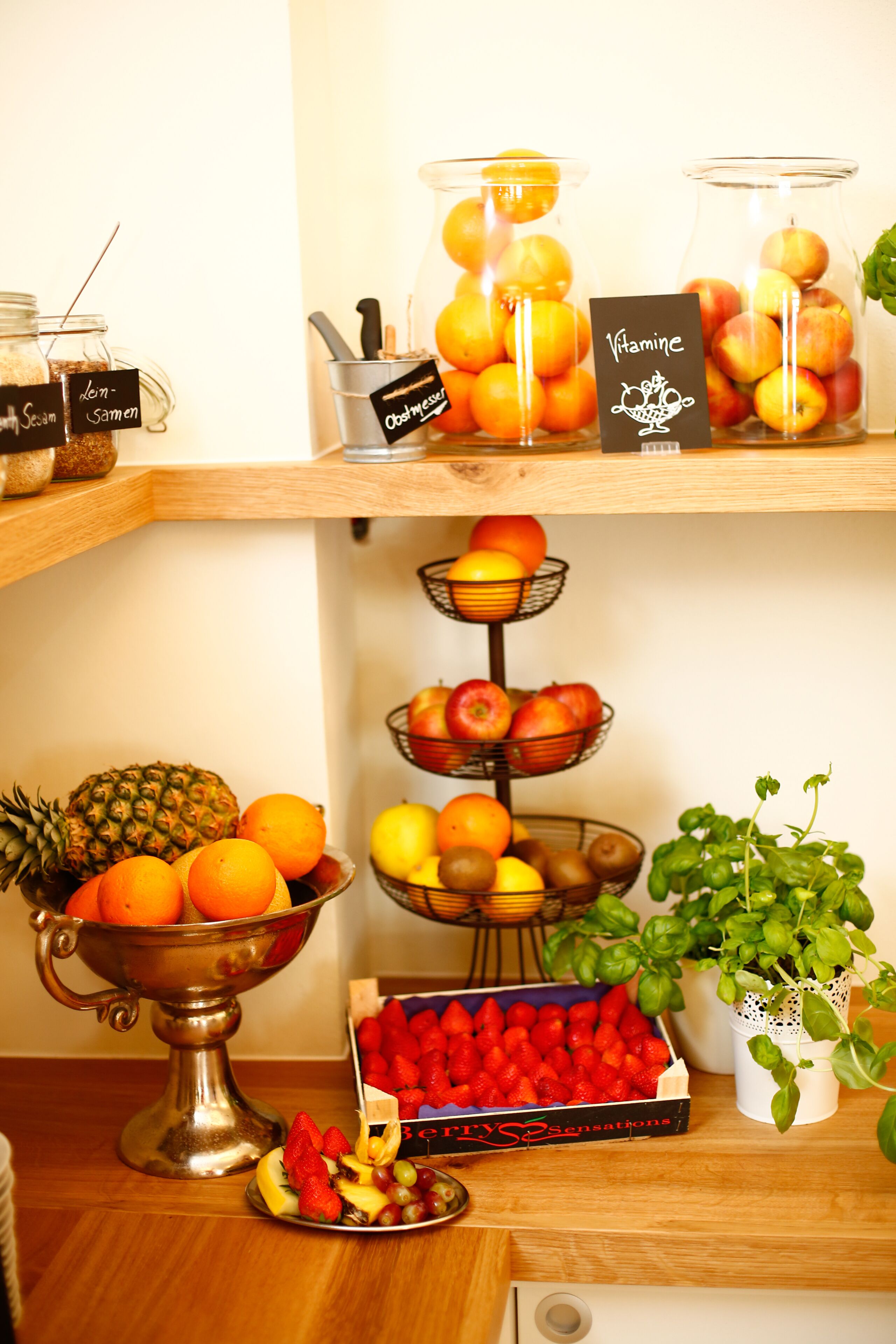 Una exposición de frutas con diversas variedades y un cartel que indica el contenido de vitaminas.