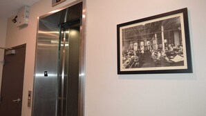 An elevator with a star symbol, a framed black and white photograph on the wall, and a door with a handle. - Investigative reporting themed, Historic luxury condo, 2 blocks from French Quarter (New Orleans)