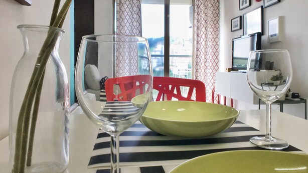 Zona pranzo con tavolo, sedie e un vaso con fiori.