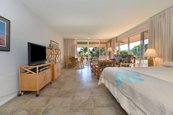 A hotel room with a bed, TV, wooden furniture, and large windows. - Top Floor, Corner Unit, Pool View, Kaanapali Beach (Kaanapali)
