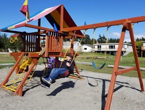 Un parque infantil con columpios y un tobogán.