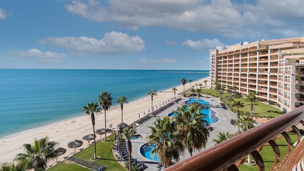 Un resort con piscina, playa y vista al océano.