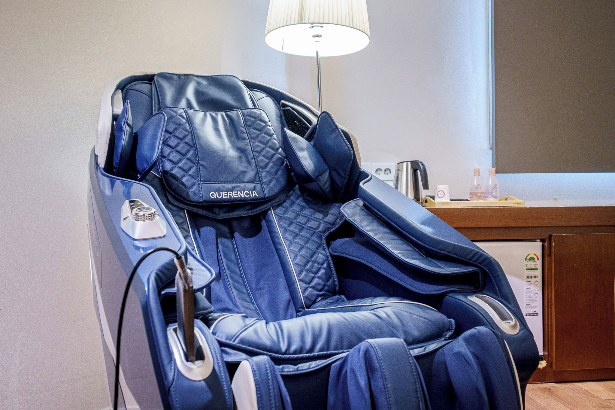 Una silla de masaje con panel de control y control remoto.