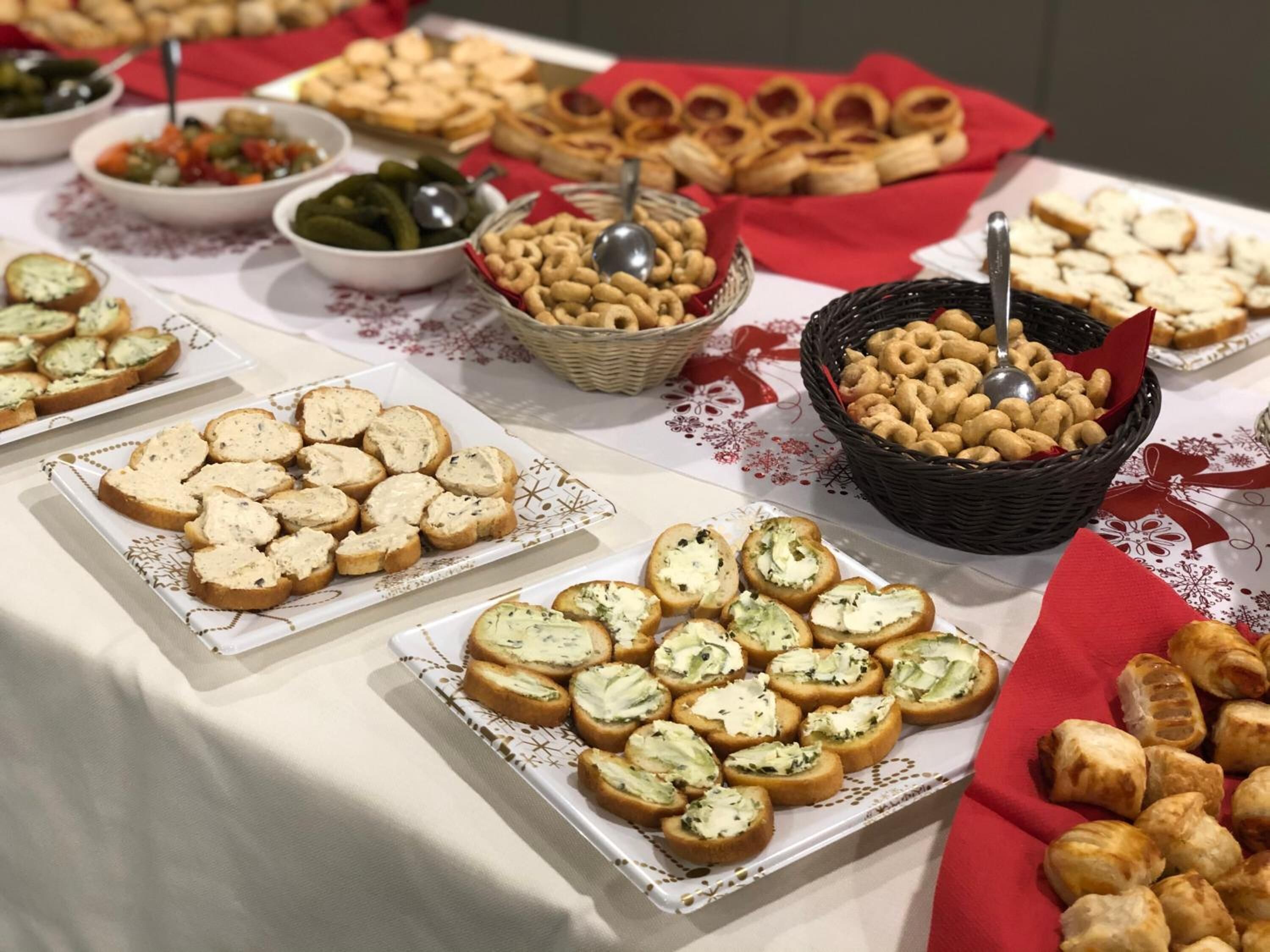 A buffet table with various food items including bread, dips, and snacks.