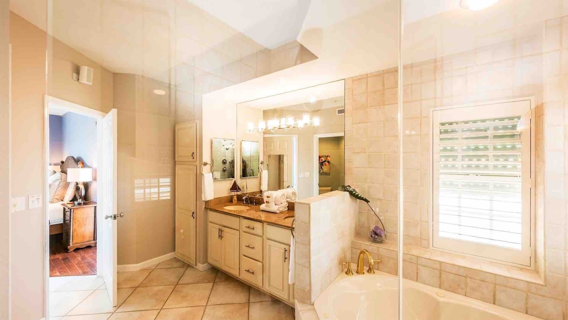 Une salle de bain moderne avec un grand miroir, une baignoire et un meuble-lavabo.