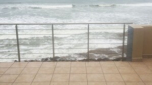 A tiled patio with a view of the ocean. - Waterfront Apartment C3 (Swakopmund)