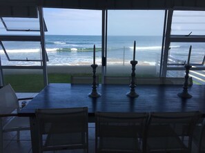 Un comedor con vistas al océano a través de amplios ventanales.