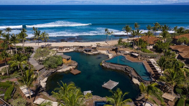 A resort with multiple swimming pools, a beach, and ocean views.