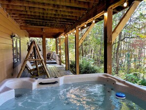 A wooden cabin with a hot tub, wooden deck, and a ladder leading to a deck chair. - American themed 9BR (sleeps 43) cabin in GBurg with tons of games and space! (GATLINBURG)