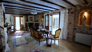 A traditional room with stone walls, a fireplace, and a dining area with wooden furniture. - Mel'Dem Butik Otel (Cesme)
