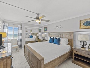 A bedroom with a large bed, bedside tables, a desk, and a ceiling fan. - 302- Beautiful Gulf-Front condominium With Exceptional Views! (Destin)