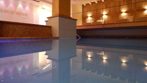 A modern lobby with a reflective floor, a reception desk, and a wooden wall with built-in lighting. - Ideal (Pinzolo)