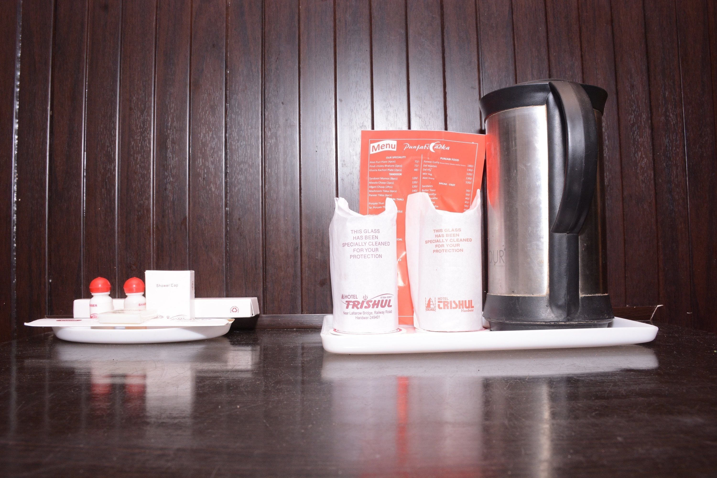 A table with a menu, a glass set, and a coffee maker.